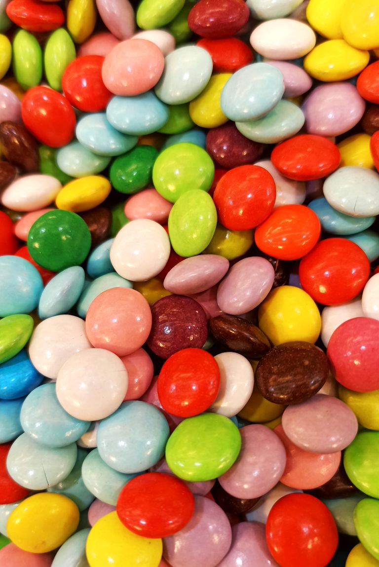 Bright and colorful assortment of candy-coated sweets creating a vibrant and playful pattern.