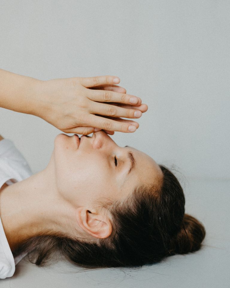 Portrait of a woman lying down with hands clasped in relaxation and serenity.