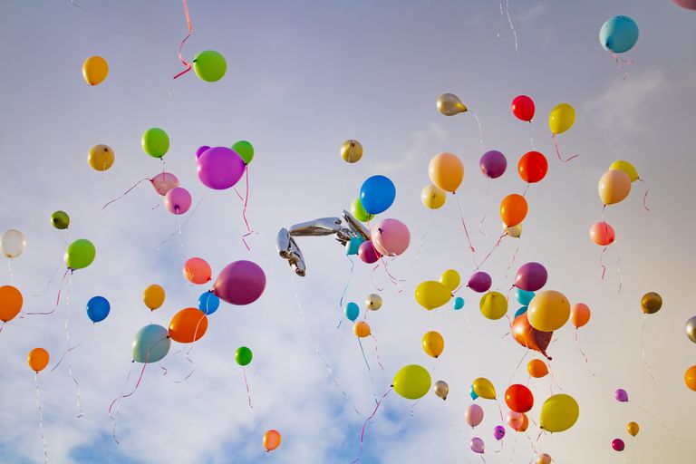 Vibrant balloons soar in the sky, creating a joyful and colorful scene against the blue backdrop.
